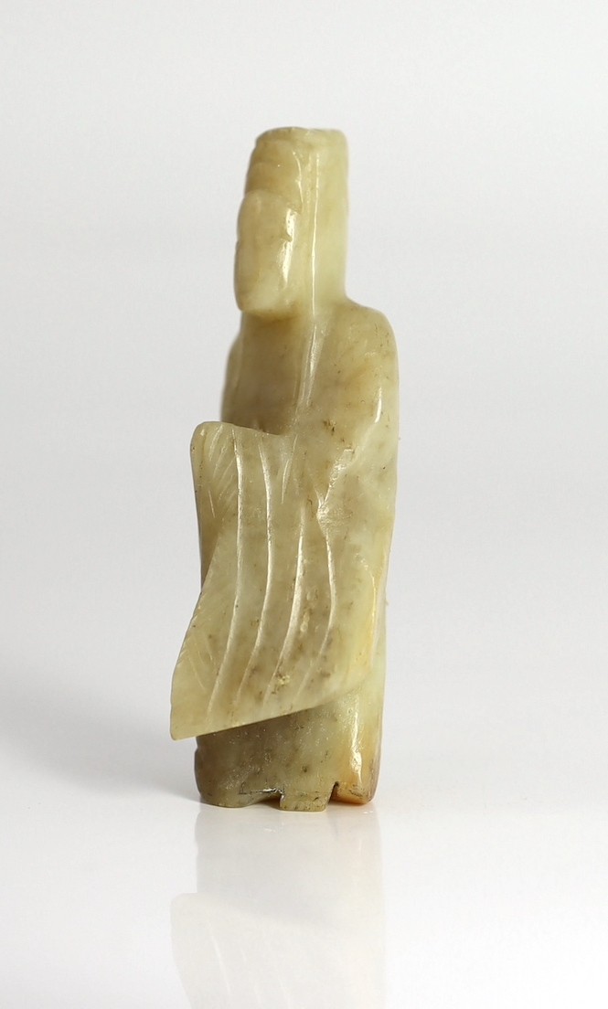 An early Chinese cream jade figure of Guanyin, together with a 19th century pale celadon and brown jade brushrest